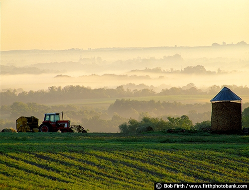 agricultural;agricultural equipment;baling hay;corn crib;farm fields;fieldwork;fog;foggy;harvesting;hay baler;summer;tractor;trees;agriculture;country;crops;hills;MN;rural;solitude;south eastern MN